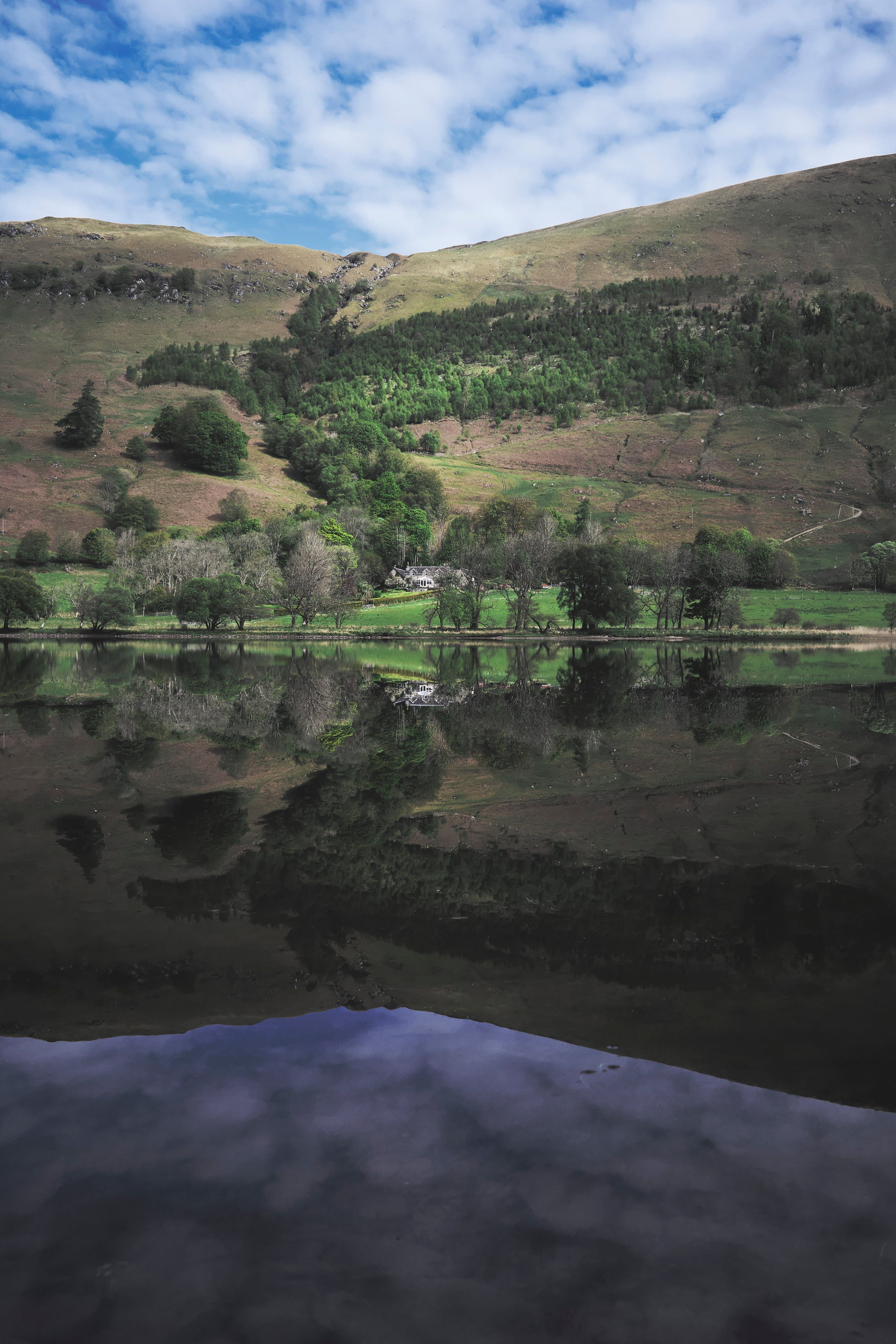 Highland cottage with hill reflected in still water